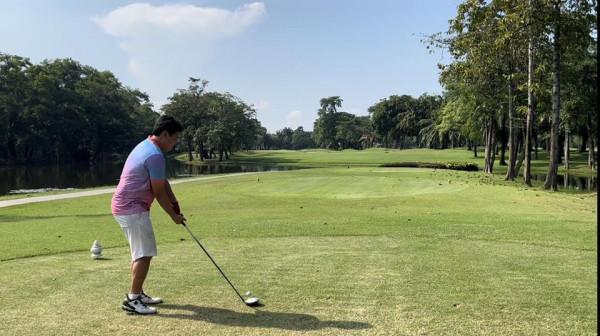 1 person playing a sport golf course grass and nature